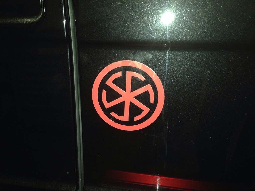 Машина знак крест. Грузинский Болнисский крест. Наклейки крестики на авто. Крест в круге на машине. Наклейка на автомобиль крест.